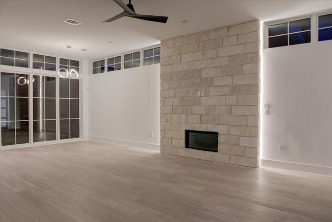 After sunset, this house gets sexy! LED lighting behind the limestone gas fireplace creates a warm nighttime ambiance. | Image 18