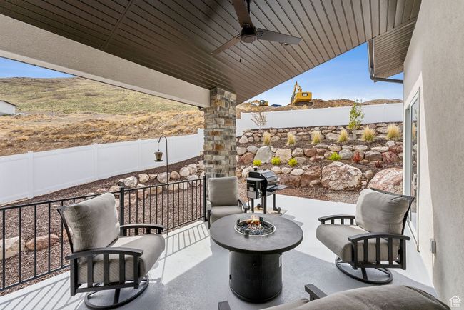 View of patio with ceiling fan, a fenced backyard, and an outdoor fire pit | Image 60