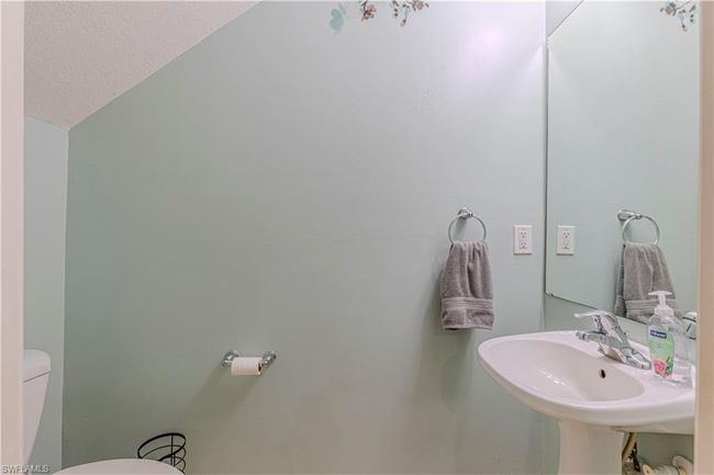 Bathroom featuring toilet, a textured ceiling, a sink, and lofted ceiling | Image 21