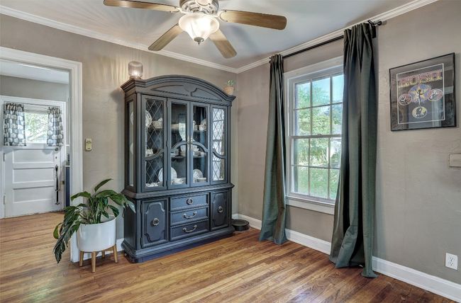 Unfurnished room featuring light wood finished floors, ceiling fan, a wealth of natural light, and ornamental molding | Image 10