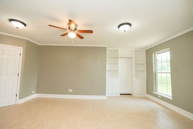 Unfurnished bedroom with a textured ceiling, a closet, and ornamental molding | Image 29