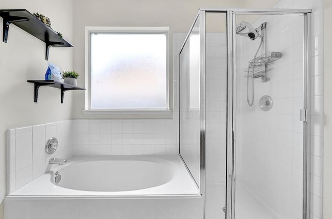 Whether you prefer a shower or a relaxing soak in the tub, this home has got you covered! The room stays bright, yet private, with the frosted window. | Image 18