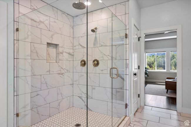 Primary full bathroom with a shower stall, ensuite bathroom, and baseboards | Image 33