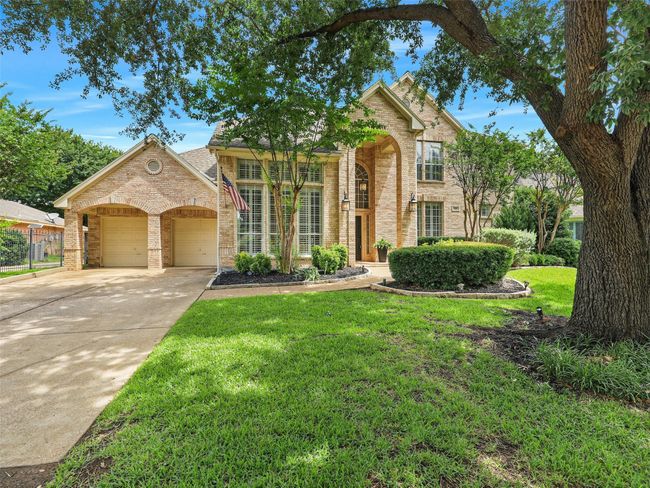 Traditional home with brick siding, a garage, a front yard, and driveway | Image 5