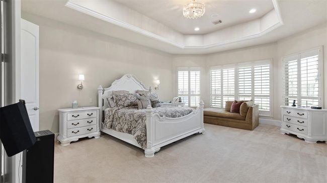 Retire to this absolutely stunning Owner's Suite gorgeously lit with a romantic chandelier, dramatic 11ft tray ceilings, curved bay windows and wall sconces! | Image 31