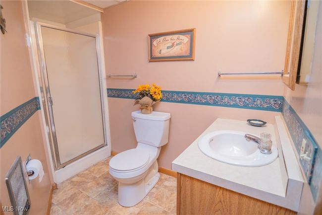 Bathroom featuring toilet, a shower stall, and vanity | Image 9