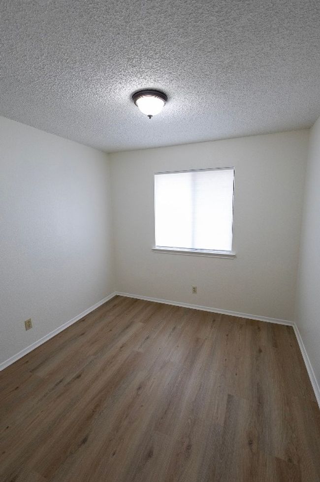 Spare room with wood finished floors, a textured ceiling, and baseboards | Image 20