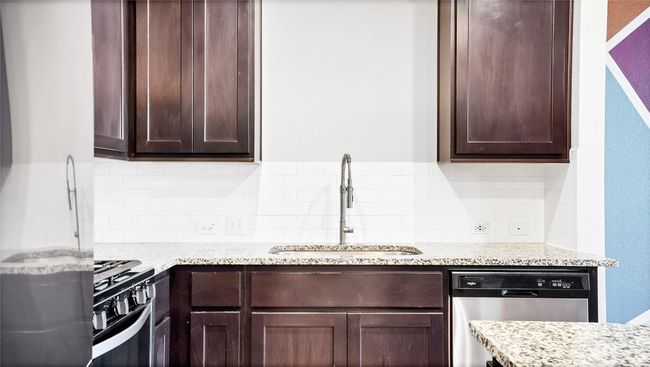 Kitchen with dark brown cabinets, dishwasher, a sink, and range with gas cooktop | Image 5