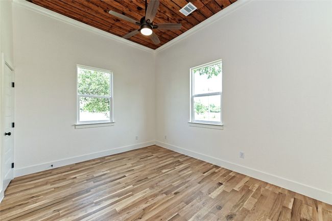 Spare room featuring wooden ceiling, plenty of natural light, ornamental molding, ceiling fan, and light wood-style floors | Image 16