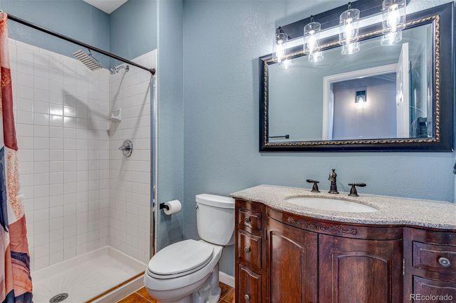 Full bathroom featuring toilet, a shower stall, vanity, and a textured wall | Image 20