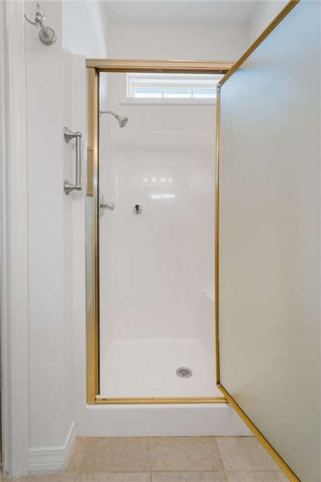 Bathroom with a shower stall and tile patterned floors | Image 22