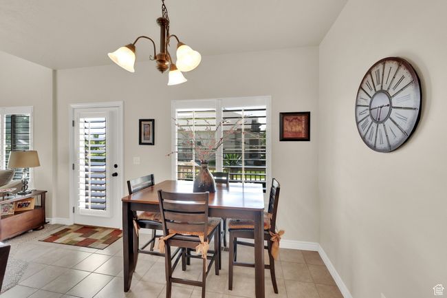 Dining area with light tile patterned floors and a chandelier | Image 9