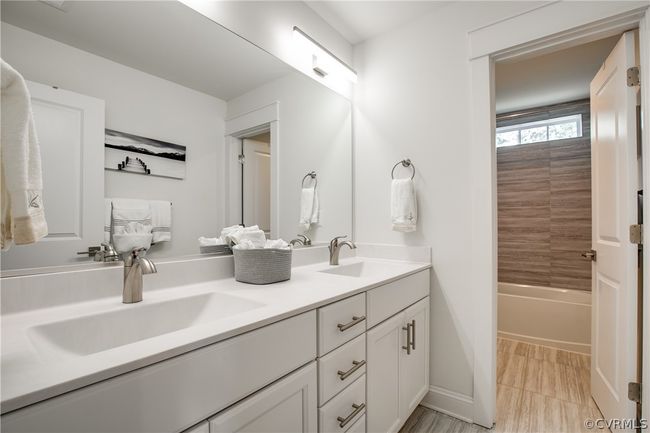 Bathroom featuring tile flooring, oversized vanity, double sink, and shower / bathtub combination | Image 35