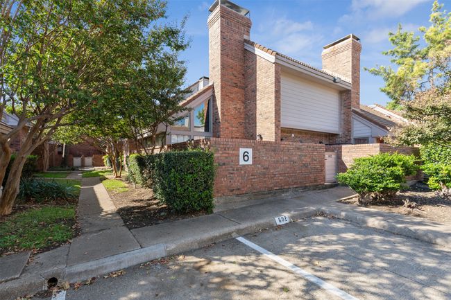 View of side of property featuring a tiled roof, brick siding, fence, and a chimney | Image 24