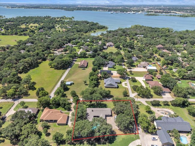 Aerial view of residential area with a large body of water and property boundaries highlighted | Image 38