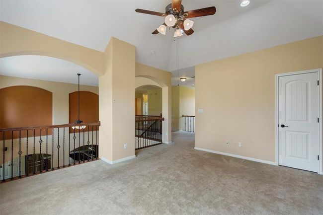 Spare room featuring ceiling fan, carpet flooring, baseboards, arched walkways, and vaulted ceiling | Image 18