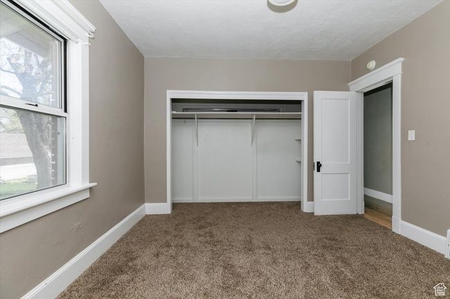 Unfurnished bedroom with baseboards, visible vents, a textured ceiling, and finished concrete flooring | Image 21