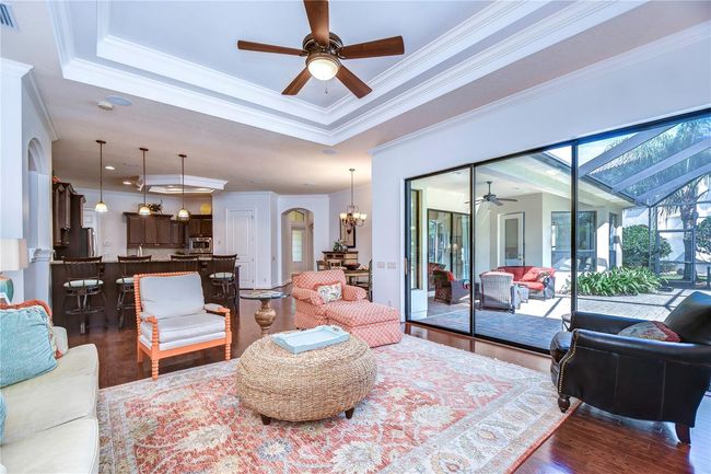 Step into elegance with this open-concept living area, where natural light dances through expansive glass doors. | Image 16