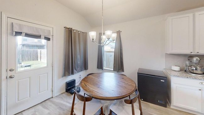 Dining area with light wood-style floors, a chandelier, and vaulted ceiling | Image 7