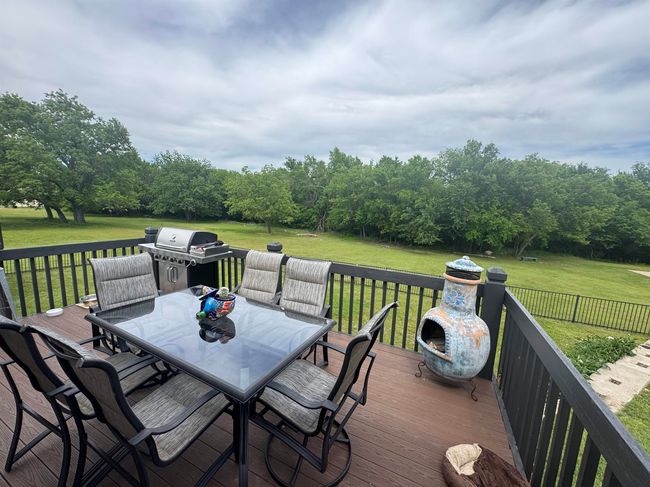 Wooden deck featuring outdoor dining space, a grill, and a lawn | Image 25