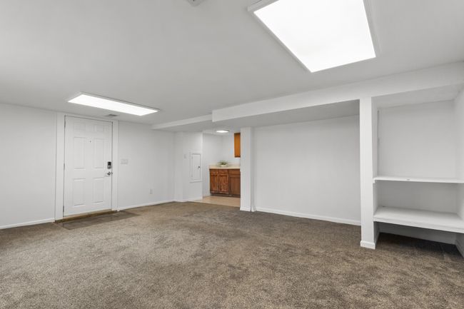 Family Room offers a built-in storage niche, entry door with access to the porch and a wet bar | Image 25