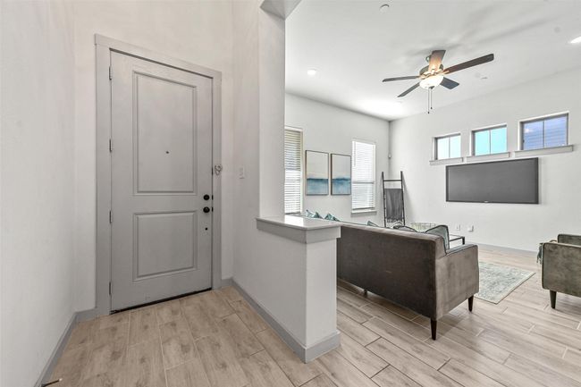 Living room with ceiling fan and light wood-type flooring | Image 8