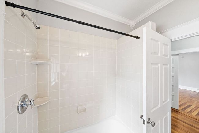 Full bath featuring ornamental molding, wood finished floors, and shower / bathtub combination | Image 16
