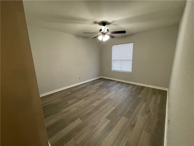 Empty room featuring ceiling fan and dark wood-type flooring | Image 7