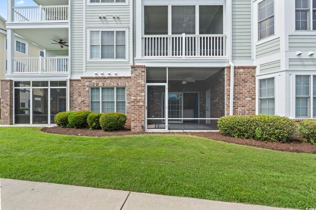 Doorway to property featuring a ceiling fan, brick siding, and a balcony | Image 13