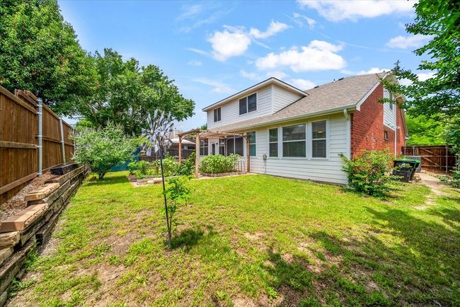 Rear view of property featuring a garden, brick siding, and a shingled roof | Image 36