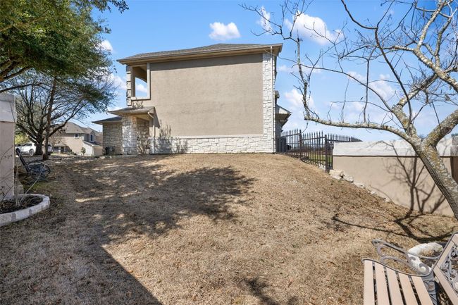 View of home's private side exterior featuring stone siding, fence, and stucco siding | Image 35