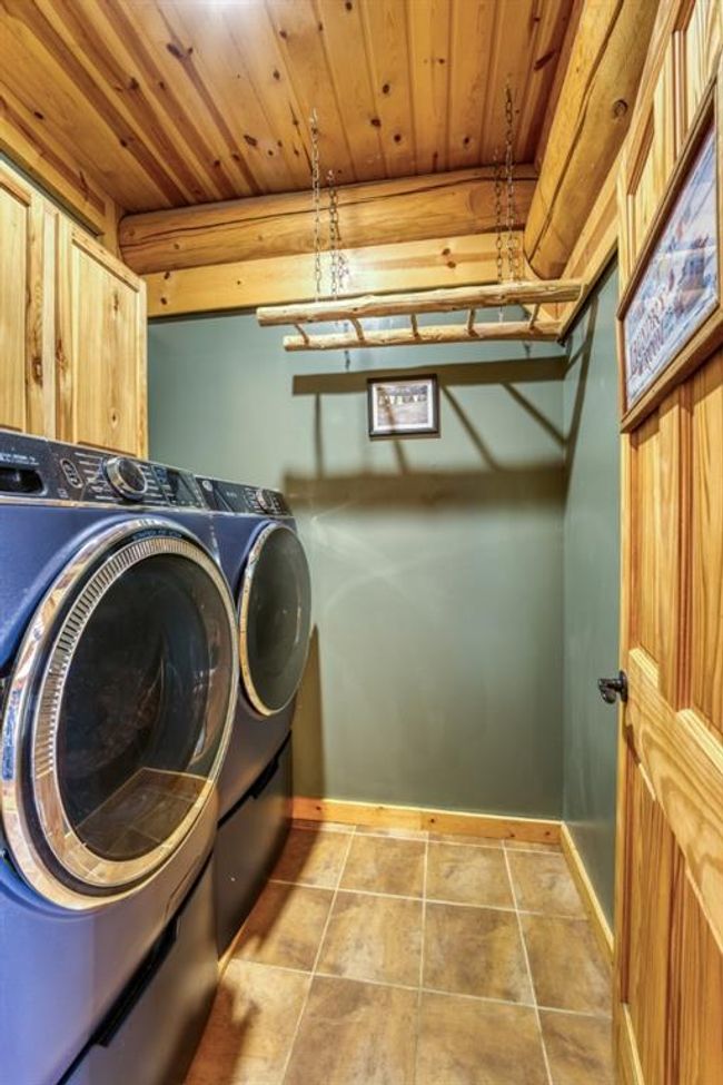 Washroom with baseboards, laundry area, tile patterned flooring, wood ceiling, and washer and clothes dryer | Image 25