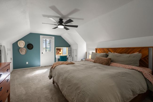 Carpeted bedroom featuring lofted ceiling, a ceiling fan, and baseboards | Image 30