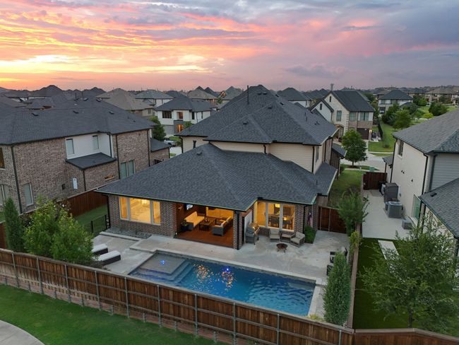 Back of house at dusk with outdoor lounge area, a fenced backyard, brick siding, and a residential view | Image 32