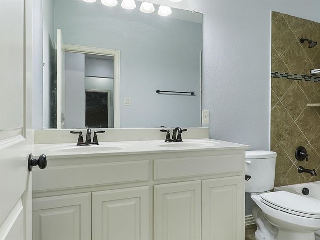 Full bath with double vanity, shower / tub combination, and a textured wall | Image 33
