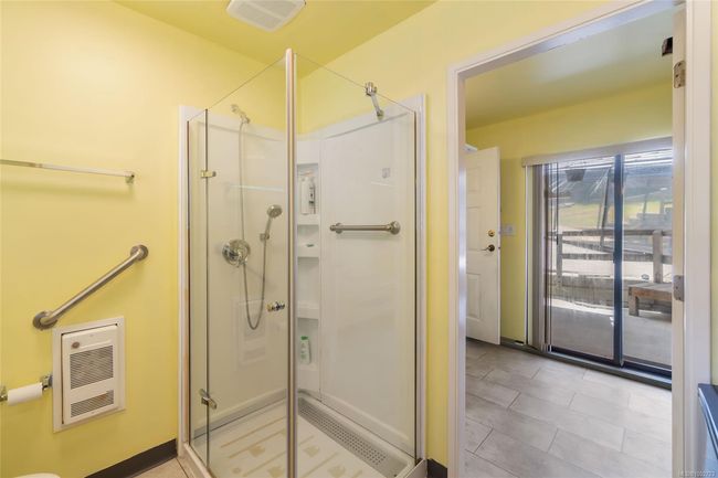Bathroom with heating unit, a stall shower, and tile patterned floors | Image 42