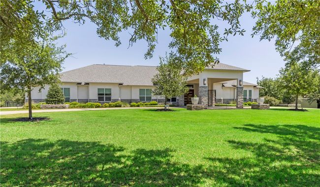 View of front of house featuring stucco siding, stone siding, and a front lawn | Image 6