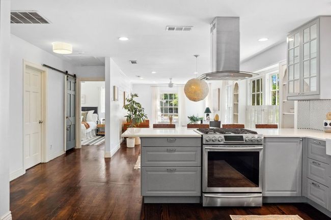 A gas range built into the large peninsula with quartz counters make this dreamy kitchen a fantastic place to prepare meals and hang out. | Image 5
