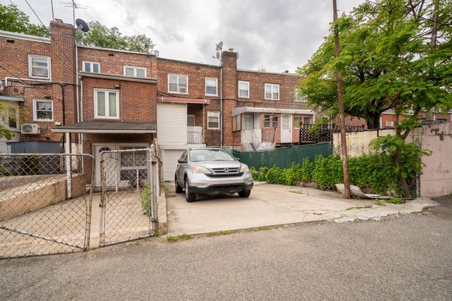 View of front of property with a gate, an attached garage, brick siding, and concrete driveway | Image 28