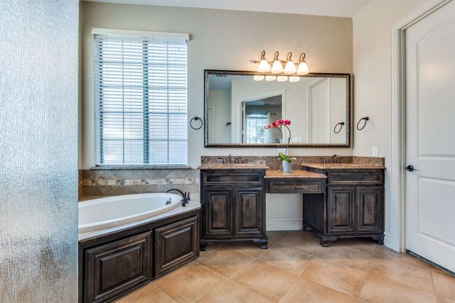 Full bathroom with tile patterned floors, a bath, double vanity, and a sink | Image 27