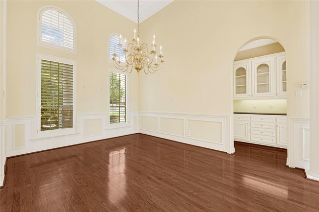 Elegant dining area with a stunning chandelier and custom built-in buffet. | Image 12