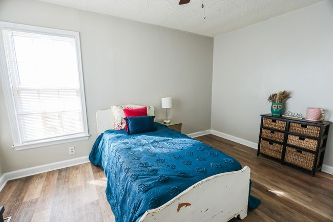 Bedroom with a textured ceiling, baseboards, and wood finished floors | Image 26