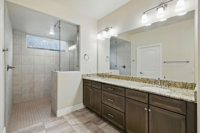 Full bath with double vanity, a walk in shower, and tile floor | Image 14
