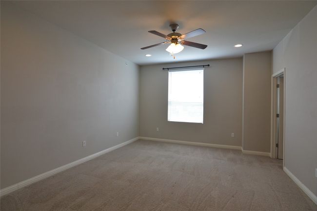 Bedroom 1 of 3 featuring a ceiling fan, light carpet, baseboards, and recessed lighting | Image 23