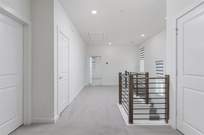 Hallway featuring attic access, an upstairs landing, light colored carpet, recessed lighting, and healthy amount of natural light | Image 13