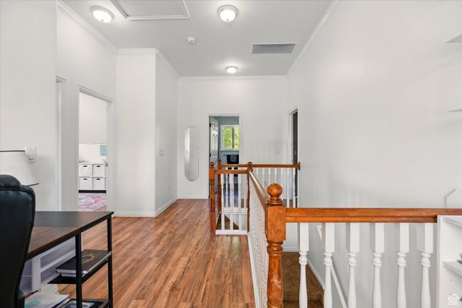 Hall with an upstairs landing, crown molding, wood finished floors, and baseboards | Image 11