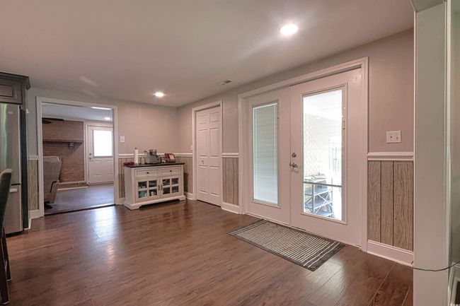 Doorway with french doors, dark wood-type flooring, wainscoting, and recessed lighting | Image 8