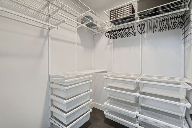 Spacious closet with dark tile patterned floors | Image 14