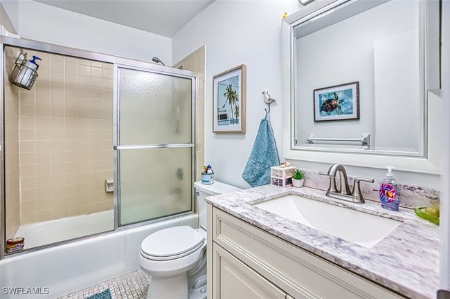 Bathroom featuring vanity and combined bath / shower with glass door | Image 26