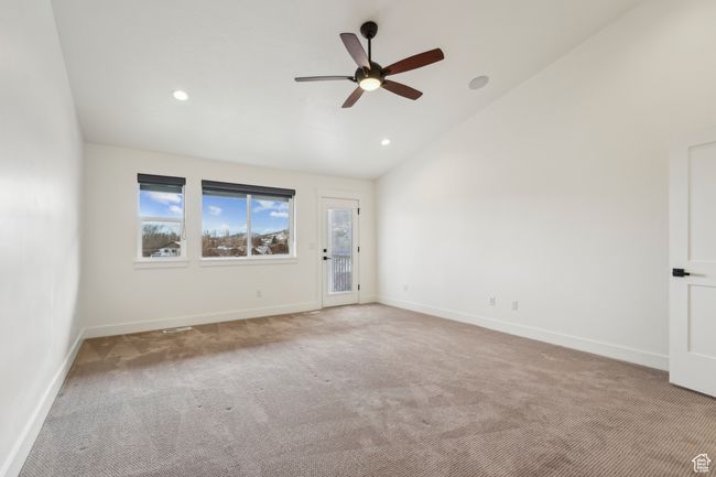 Spare room featuring baseboards, carpet floors, ceiling fan, and vaulted ceiling | Image 25